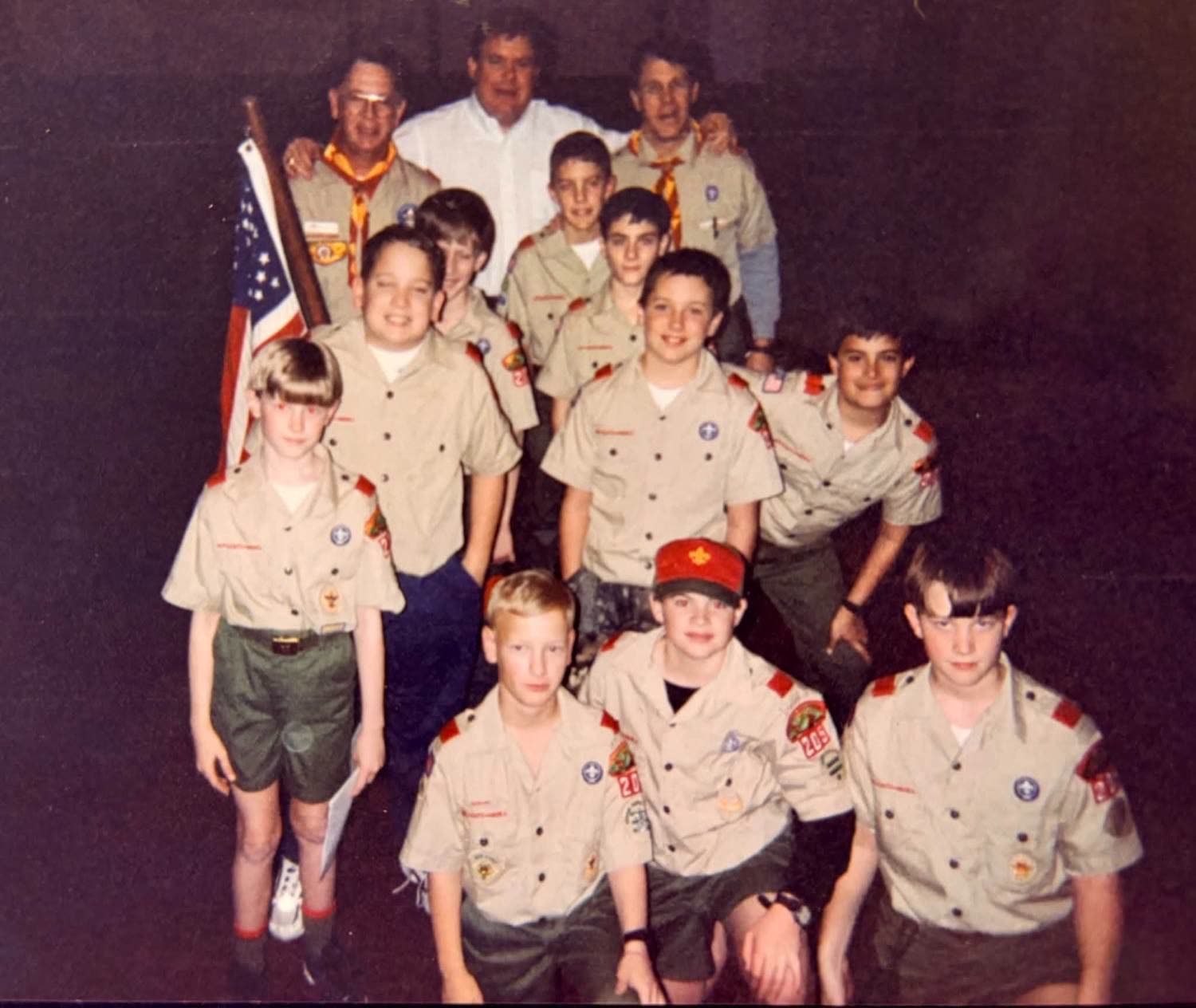 Troop 205's early scouts in uniform with their leaders and the American flag, late 1990s