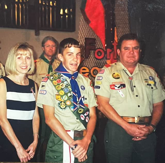 An Eagle Scout with family and Scoutmaster